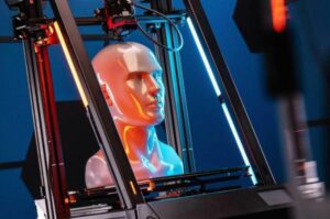 3D printer building a human head model under blue lighting