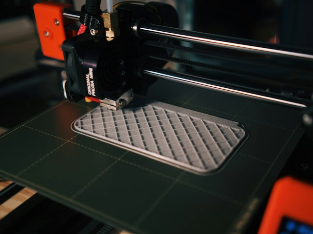 3D printer printing a grille-shaped plastic part